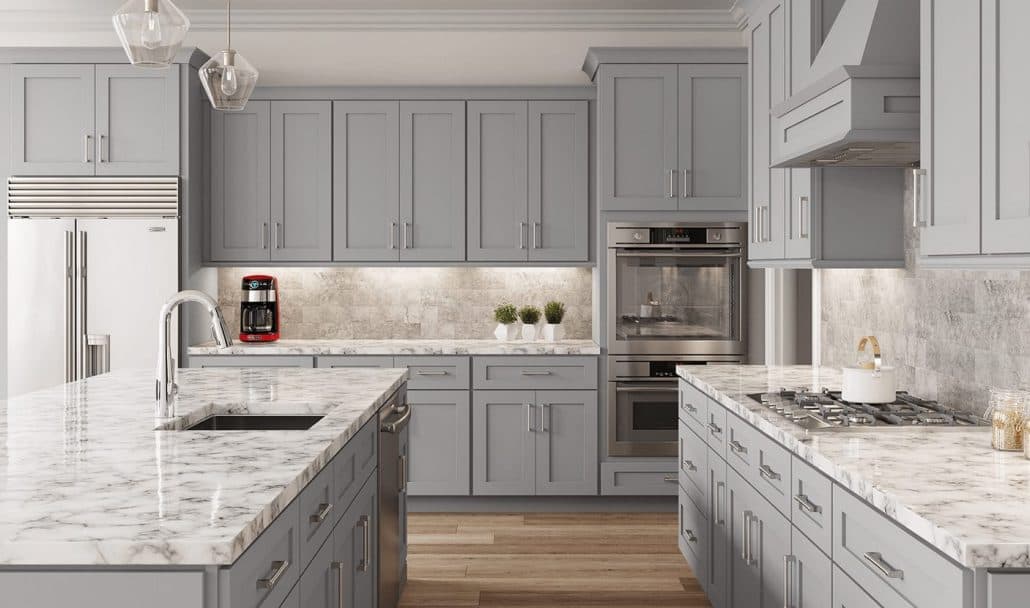 Gray shaker cabinet kitchen with marble countertops and an island